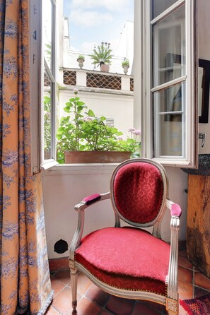 A room with a window, a chair, and a curtain. - Bonne Nuit Paris (Paris)