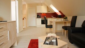 A modern apartment with a kitchen, dining area, and living room. - Apartment Strandstrasse 10 / Büsum (Büsum)