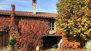 A house with a tiled roof, a chimney, and ivy-covered walls. - Gite with pool close to the pyrenees & ancient Abbey of Saint Sever de Rustan (Saint-Sever-de-Rustan)