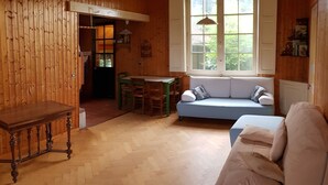 Un intérieur en bois comprenant une table à manger, un canapé et une fenêtre donnant sur un paysage agréable.