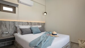 Een moderne slaapkamer met een bed, nachtkastje en hanglamp.