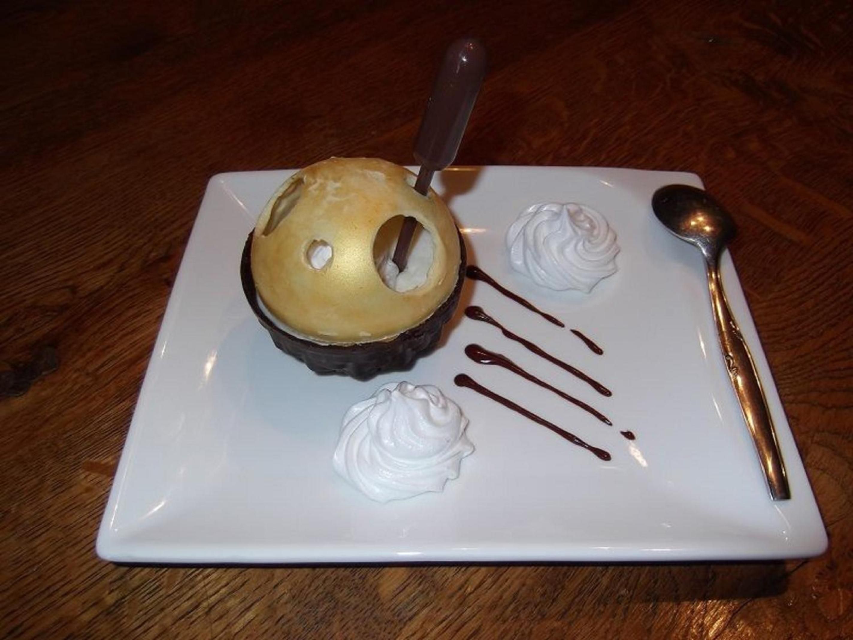 A dessert plate with a chocolate cake, whipped cream, and chocolate sauce.