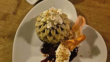 Two white plates with desserts on a wooden table.