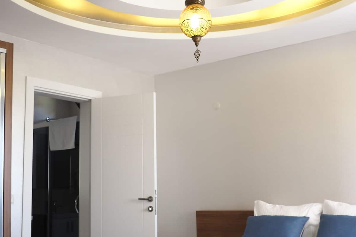 Ein Hotelzimmer mit einem Bett, einem Nachttisch und einer Deckenleuchte.