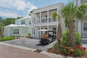 A two-story building with a covered porch and a golf cart parked in front.