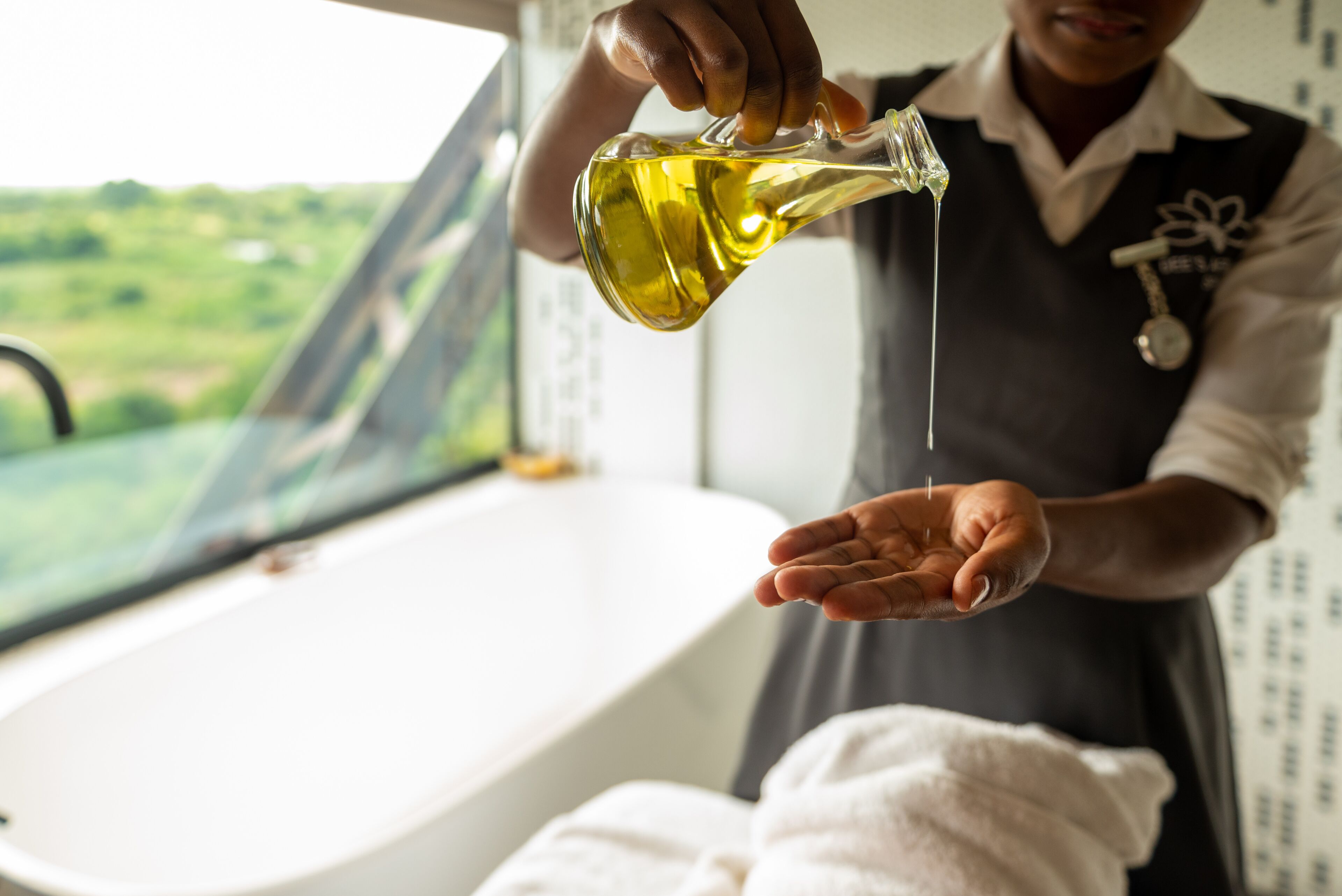 A person pouring oil into a hand.