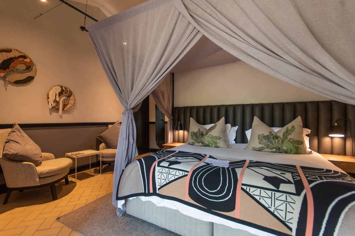 Une chambre à coucher avec un lit à baldaquin, un canapé et une petite table.