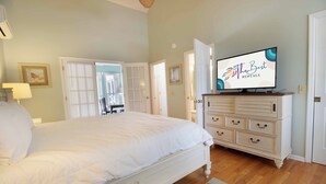 Un dormitori amb un llit gran, un aparador i una televisió que mostra 'The Best Rentals'.