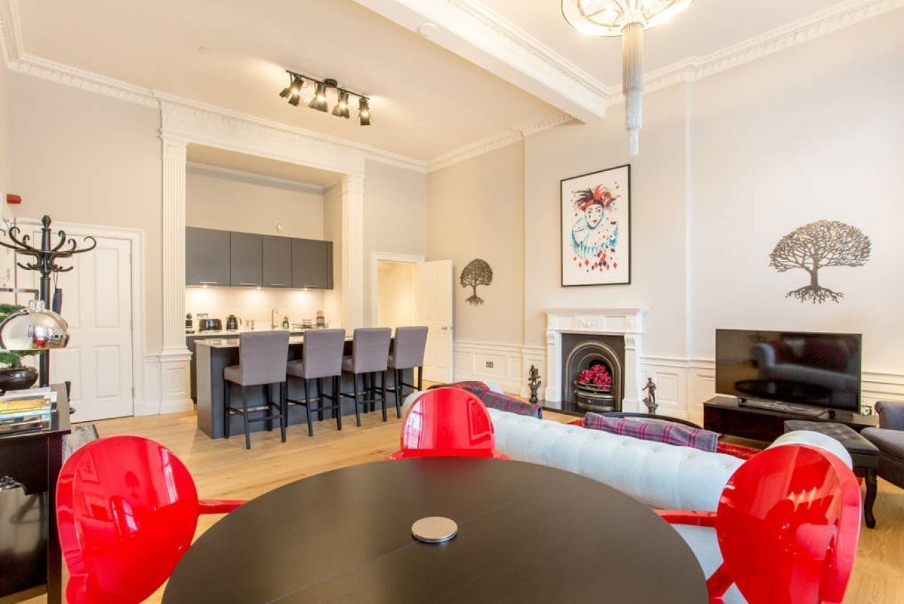 Un salon moderne comprenant un coin repas, une cheminée et un téléviseur.