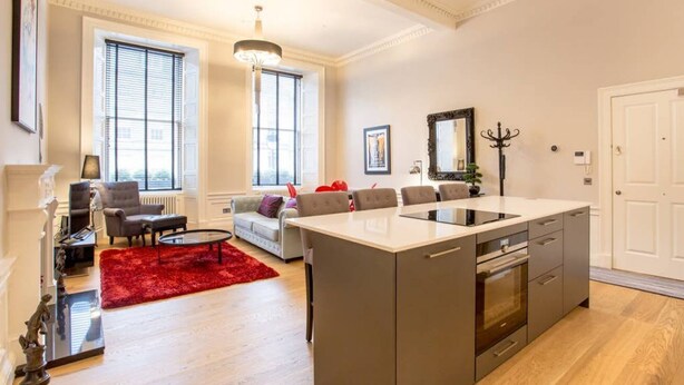 Un appartement moderne comprenant une cuisine, un coin repas et un salon.