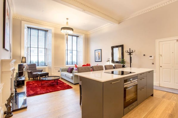 A modern apartment with a kitchen, dining area, and living room.