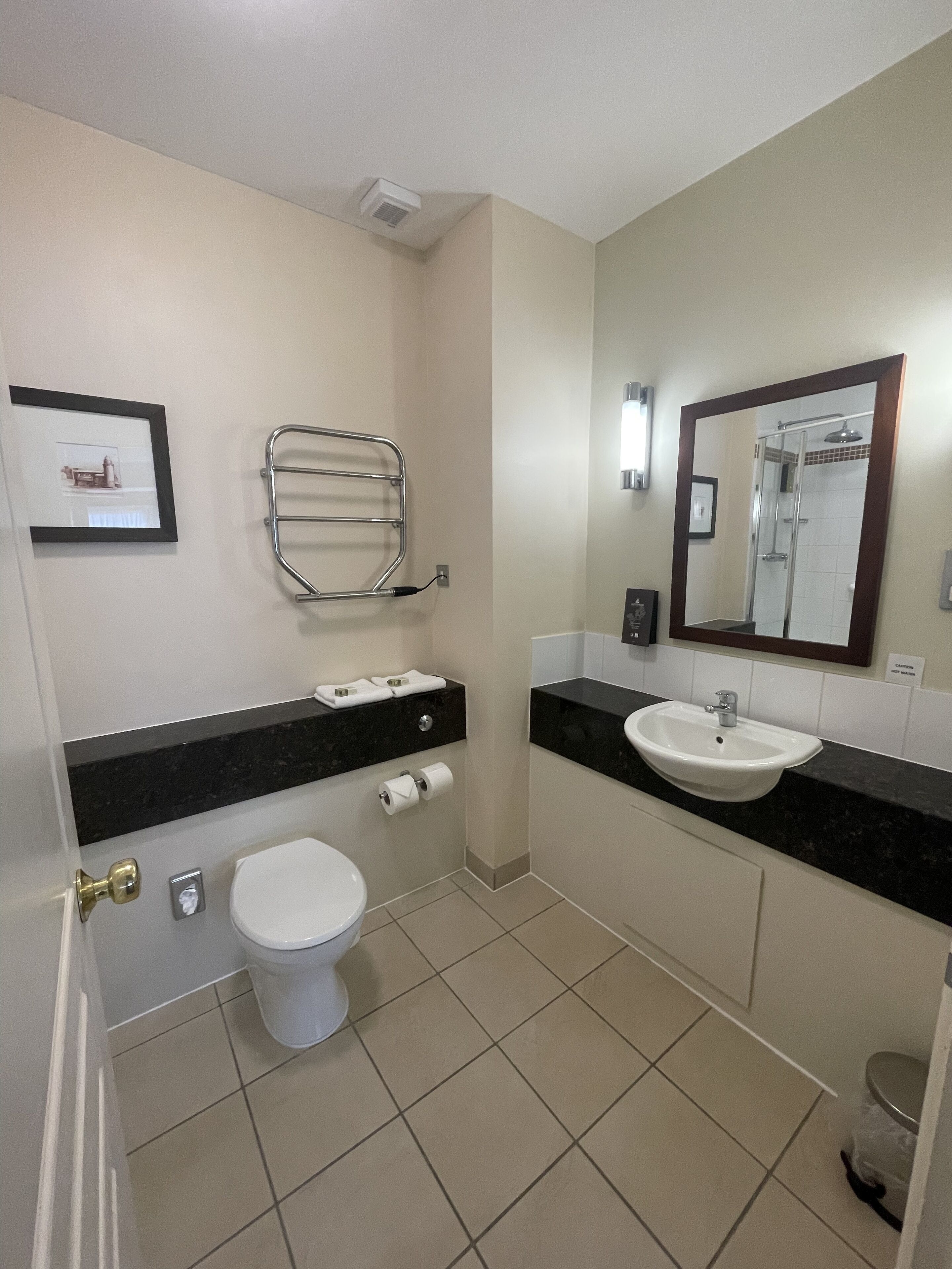 Un baño moderno con inodoro, lavamanos y ducha.