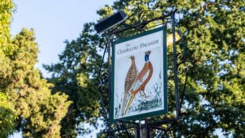 A sign with two pheasants and the text "The Charlecot Pheasant".