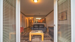 A living room with a sofa, a coffee table, and a kitchen in the background. - Unit 2307 - FREE Attraction Ticket with EACH night Stay Including Dollywood (Pigeon Forge)