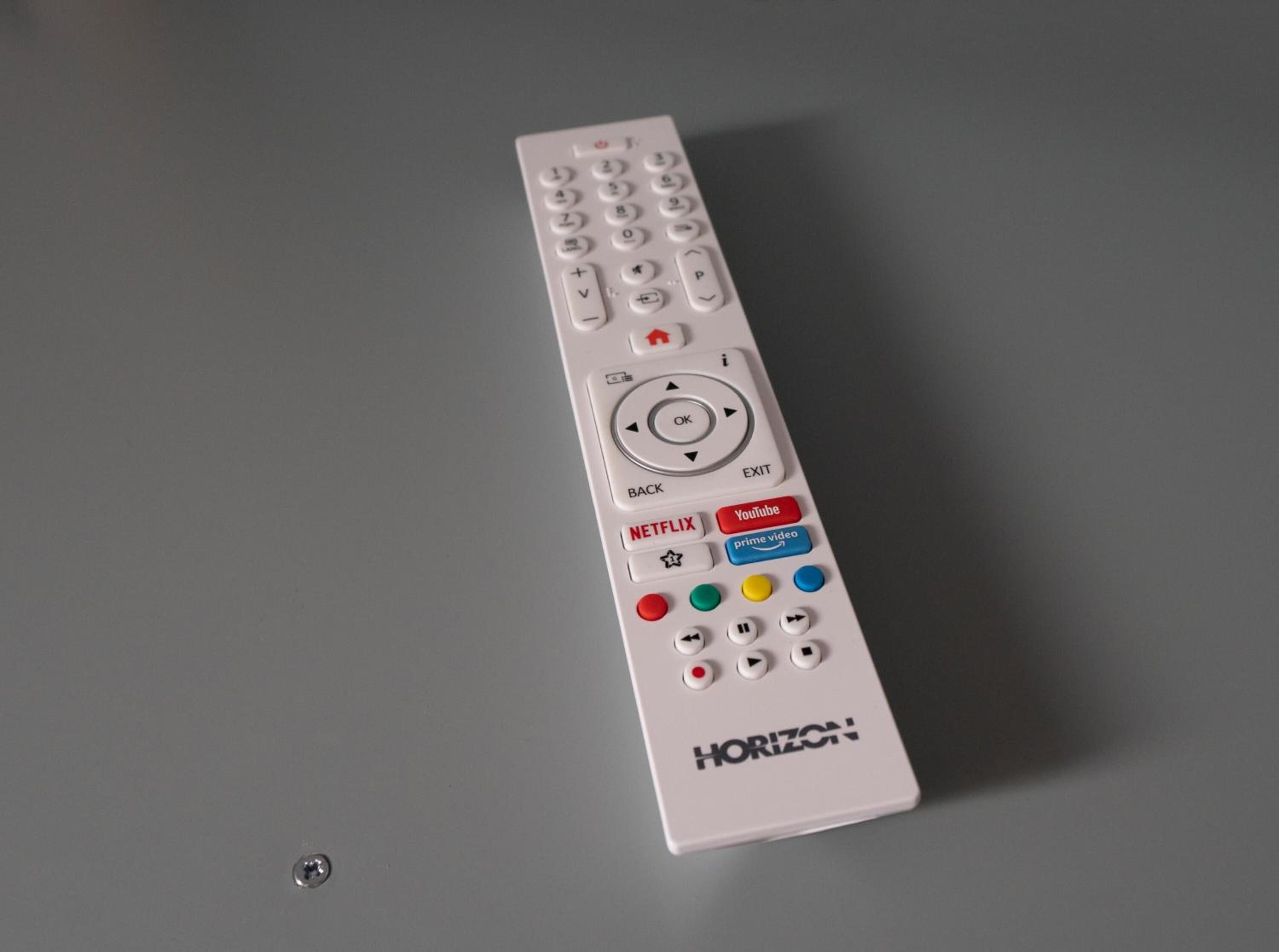 Un control remoto blanco con un panel de navegación circular, un pad direccional y botones para Netflix, YouTube y Prime Video.
