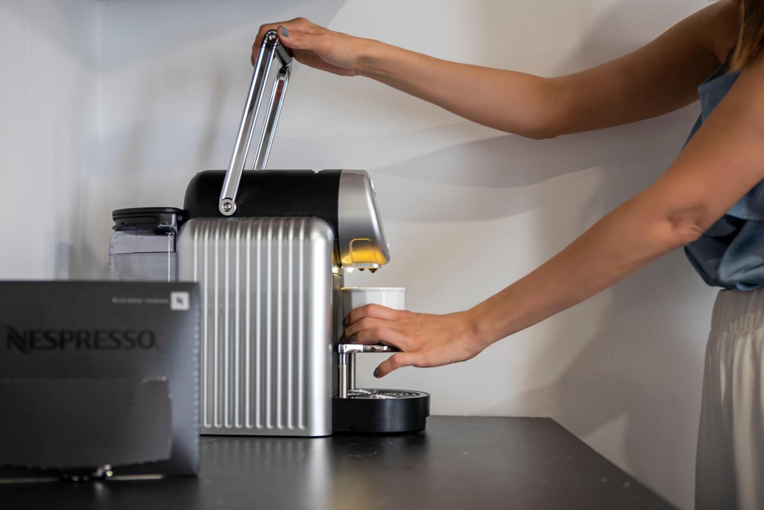 Una persona usando una cafetera Nespresso.