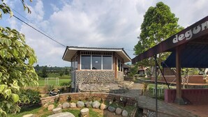 Una casa con fachada de piedra, un ventanal grande y un camino de piedra que lleva a la entrada.