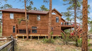 A wooden cabin with a deck and staircase, surrounded by trees. - Heavenly Pines -- Ev #3361 5 Bedroom Home by RedAwning (Estes Park)