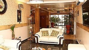 A spacious lobby with a white sofa, a coffee table, and a decorative vase. - The Carlton Gate Hotel (Ibadan)