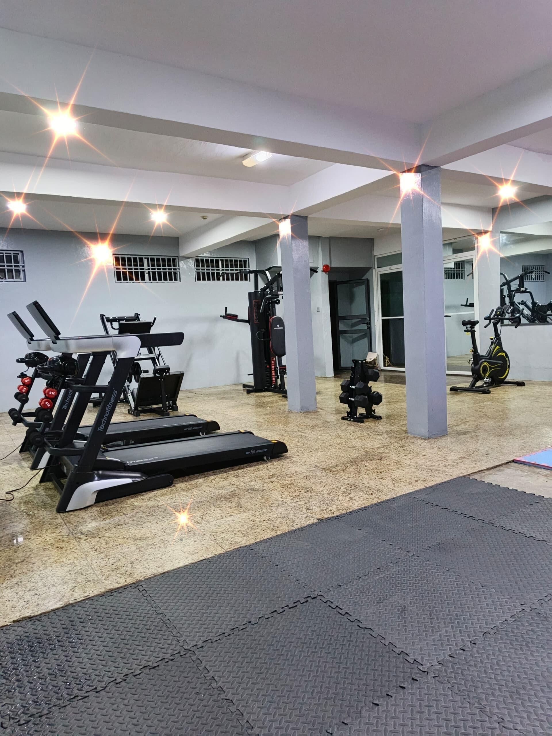 A gym with treadmills, weight machines, and a stationary bike.