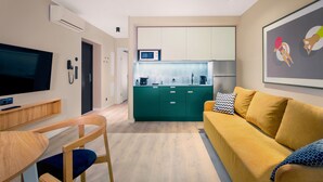A modern living room with a sofa, TV, and a kitchen in the background. - Suntago Village (Mszczonow)