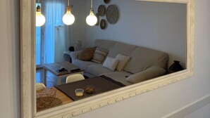 Ein Wohnzimmer mit einem großen Spiegel, einer Couch und hängenden Pendelleuchten.