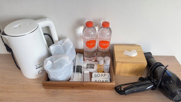 A tray with toiletries including bottles, a shower cap, soap, and a hairdryer.