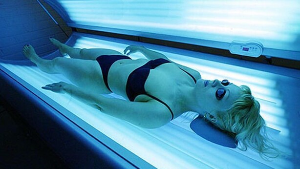 A person lying on a bed in a room with a window, a control panel, and a wall-mounted device. - CMK Bar & Spa (Milton Keynes)