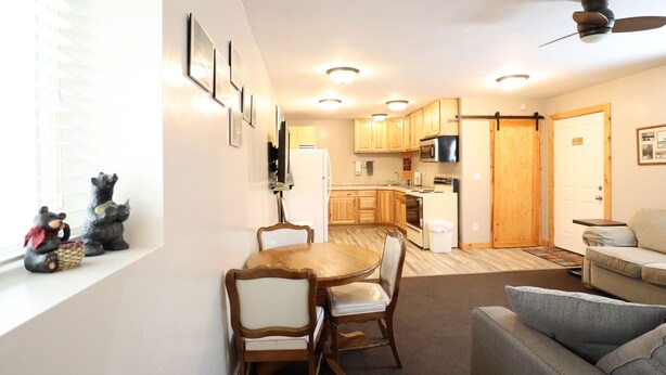 Un espacio habitable compacto con comedor, kitchenette y zona de estar.
