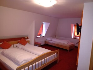 Een kamer met twee éénpersoonsbedden, een tafeltje en een raam met uitzicht.