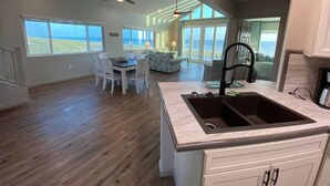 A spacious kitchen with a large island, a dining area with a view, and a living area with a view. - Your Dream Getaway - A Slice of Heaven (St Joe Beach)