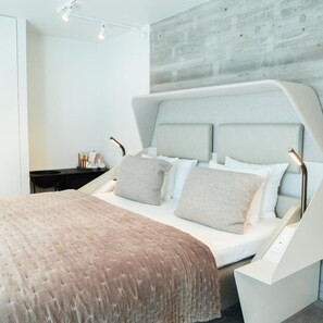 A modern bedroom with a bed, bedside tables, and a wall-mounted light fixture. - Hotel Herman K by paustian (København)