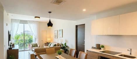 A modern apartment with a dining area, kitchen, and living space.