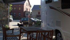 An RV parked under a covered area with a brick building in the background. - Wohnmobil PLA Siena 385 (Krostitz OT Kupsal)