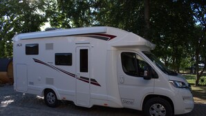 A white recreational vehicle with a sliding door, a front windshield, and a side window. - Wohnmobil PLA Siena 385 (Krostitz OT Kupsal)