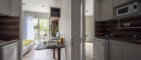 Una cocina moderna con electrodomésticos integrados, un comedor con mesa y sillas, y vistas al exterior.