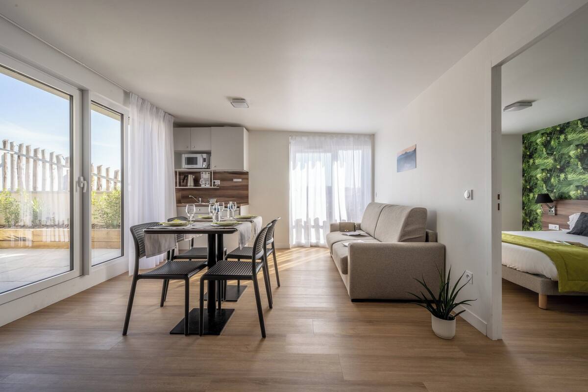 Un appartement moderne comprenant un coin repas, un salon et une chambre.