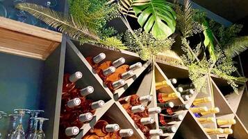 Una estantería para vinos con varias botellas y copas.
