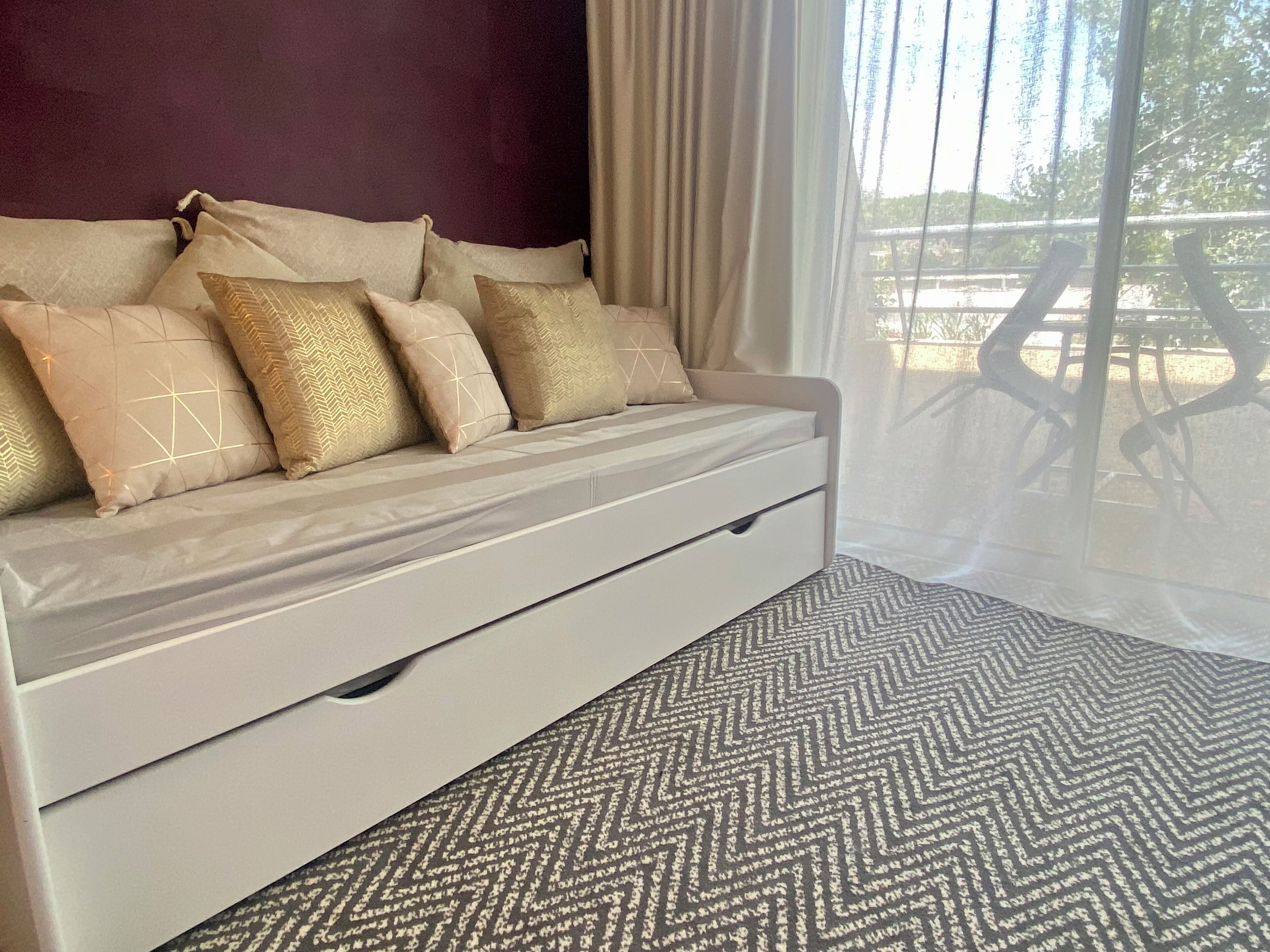 A bed with a headboard, multiple pillows, and a bedside table.