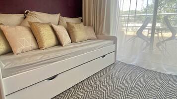 A bed with a headboard, multiple pillows, and a bedside table.