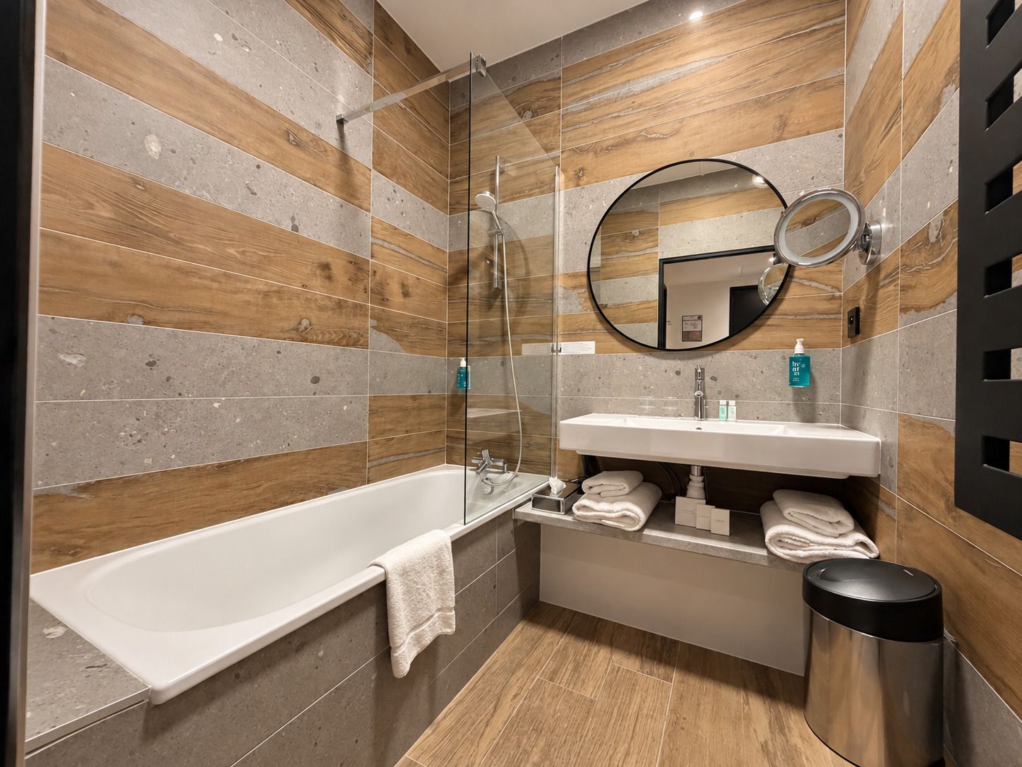 A modern bathroom with a freestanding bathtub, a vanity with a mirror, and a toilet.