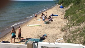 Une plage où des gens se prélassent au soleil, une planche de surf et un bateau amarré à proximité.