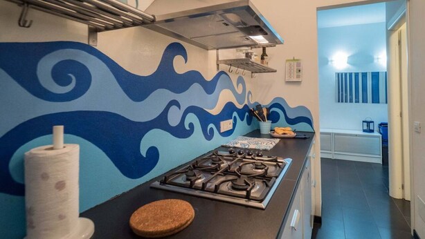 A kitchen with a gas stove, a cork mat, and a roll of paper towels. - Sciacchetrà Ground Floor Apartment with AC (Monterosso al Mare)