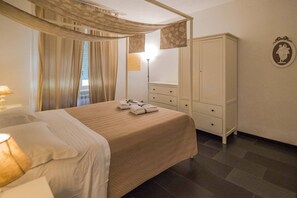 Une chambre à coucher comprenant un lit, une armoire, une table de chevet, une lampe et une fenêtre avec des rideaux.