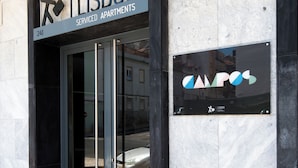 Entrada d'un edifici amb un senyal que indica 'Lisbon Serviced Apartments' i el logotip de 'CAPOS'.