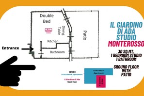 A floor plan of a studio apartment with a double bed, dining table, kitchen, and bathroom. It includes a patio and is located on the ground floor. - Il Giardino di Ada Ground Floor Studio with AC and Patio (Monterosso al Mare)