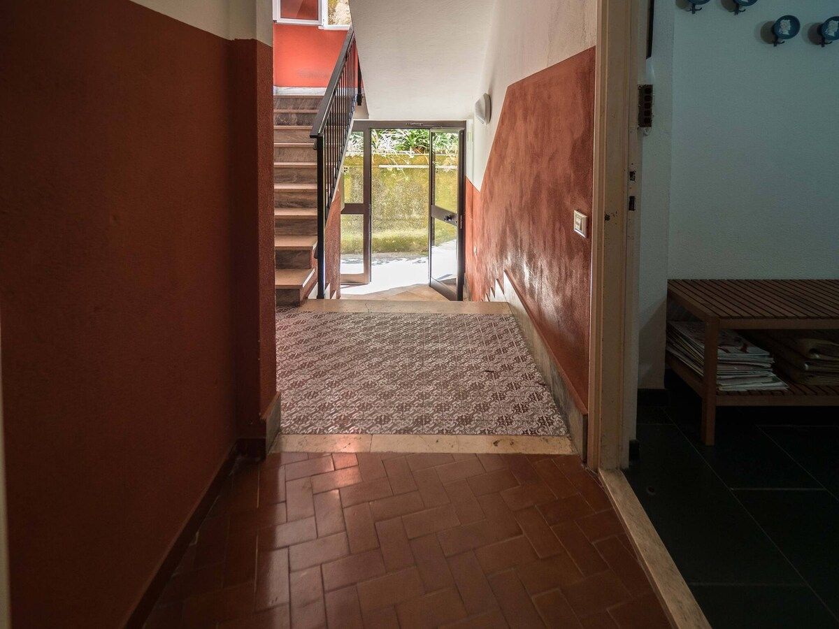 Ein Flur mit einem gemusterten Teppich, der zu einer Treppe führt.