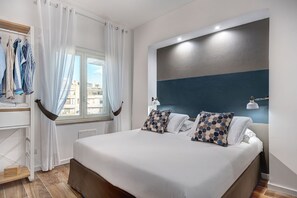 Ein modernes Schlafzimmer mit einem großen Bett, einem Fenster mit Vorhängen, einem Nachttisch und einer Wandlampe.