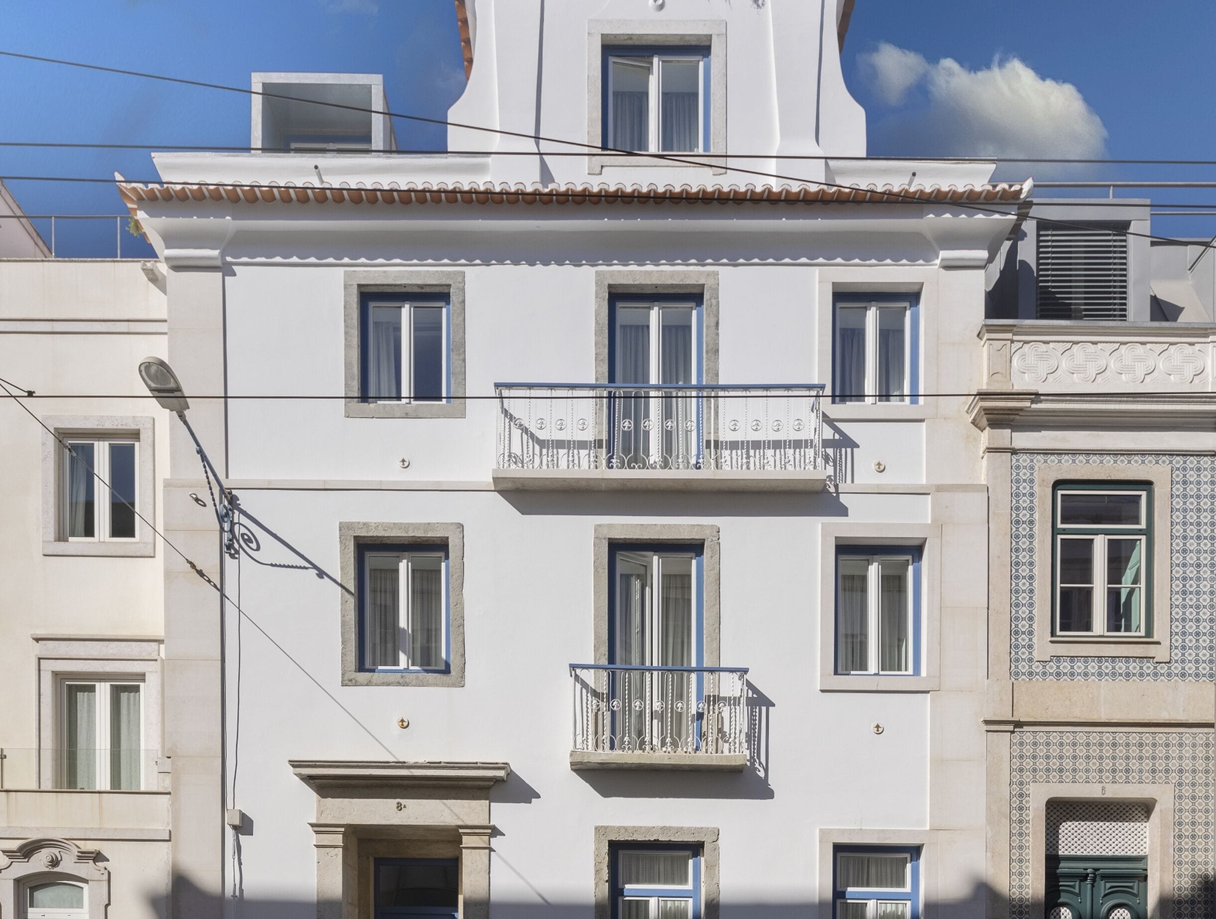 Un immeuble à plusieurs étages doté d’un balcon, de nombreuses fenêtres et d’un style architectural traditionnel.