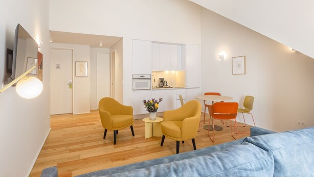 Een modern appartement met een keuken, een eethoek en een zithoek.